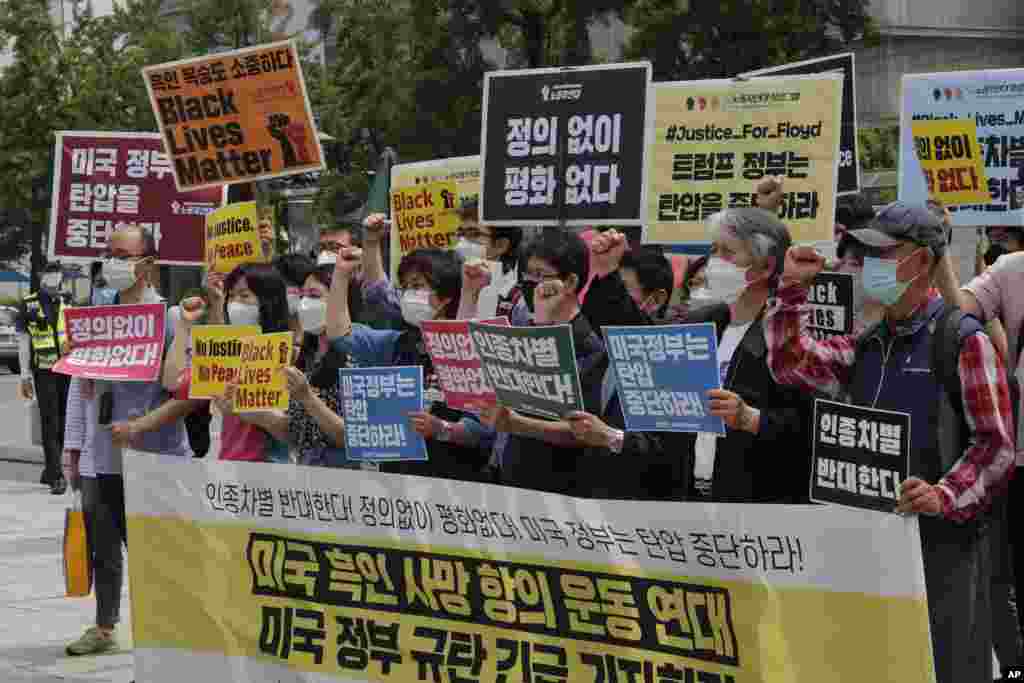 South Korean protesters shout expressions during a protest over the death of George Floyd, a black man who died on May 25 after being restrained by Minneapolis police officers, near the U.S. embassy in Seoul, South Korea, Friday, June 5, 2020. The signs read: "The U.S. government should stop oppression and There is no peace without justice." (AP Photo/Ahn Young-joon)