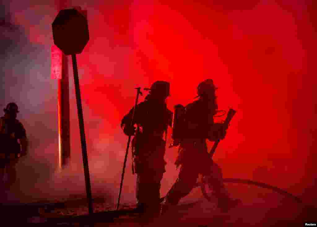 Baltimore firefighters attack a fire in a convenience store and residence during clashes after the funeral of Freddie Gray in Baltimore, Maryland in the early morning hours of April 28, 2015.