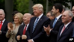 Presiden Donald Trump, diapit oleh Ketua Komite Sarana Rumah Tangga, Kevin Brady dan Ketua DPR Paul Ryan, di Taman Mawar Gedung Putih di Washington setelah DPR menyetujui dana jaminan kesehatan, 4 Mei 2017.