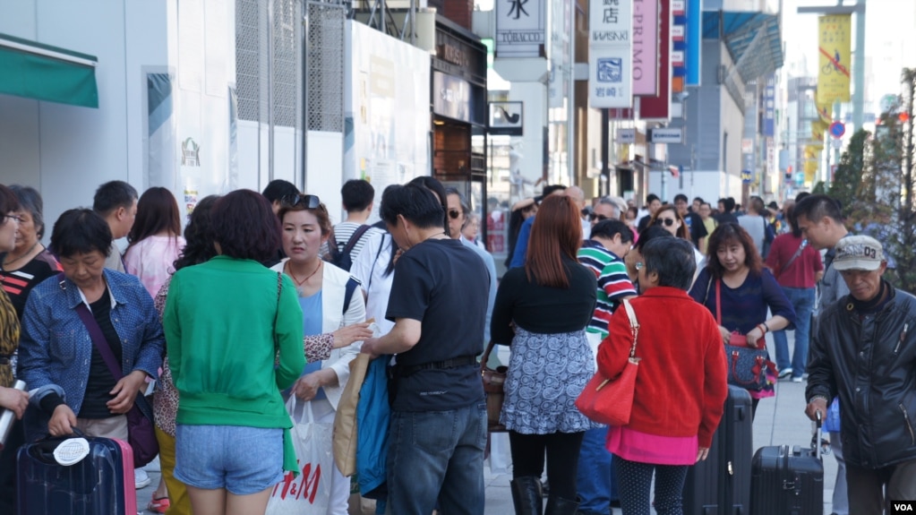 在东京繁华闹市银座，现在每天到处都是拖着皮箱“爆买”的中国游客(photo:VOA)