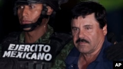 FILE - Mexican drug lord Joaquin "El Chapo" Guzman, right, is escorted by soldiers and marines to a waiting helicopter, at a federal hangar in Mexico City, Jan. 8, 2016. 