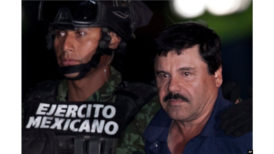 Mexican drug lord Joaquin "El Chapo" Guzman, right, is escorted by soldiers and marines to a waiting helicopter, at a federal hangar in Mexico City, Jan. 8, 2016.