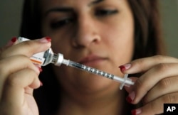 Judith Garcia, 19, fills a syringe as she prepares to give herself an injection of insulin at her home in the Los Angeles suburb of Commerce, Calif., April 29, 2012