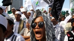 FILE - Members of the militant Islamic Defenders Front (FPI) shout slogan during a demontration in Jakarta, Indonesia.