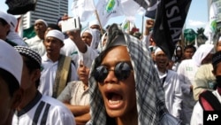 FILE - Members of the militant Islamic Defenders Front (FPI) shout slogan during a demontration in Jakarta, Indonesia.