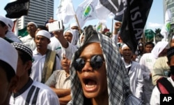 FILE - Members of the militant Islamic Defenders Front (FPI) shout slogan during a demontration in Jakarta, Indonesia.