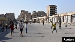 People walk along a street in Deir el Zour, Syria, in this photo provided by SANA, Sept. 11, 2017.