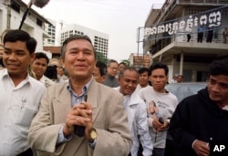FILE - Kem Sokha, former chairman of the Cambodian parliament's human rights commission, center, greets the press as he leaves the Phnom Penh Municipal Court in Cambodia Tuesday, Dec. 15, 1998.