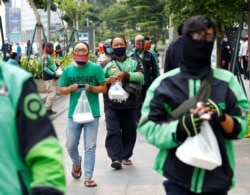 Pengemudi ojek online antre bantuan makanan gratis di tengah pandemi virus corona (COVID-19), di Jakarta, 17 April 2020. (Foto: Reuters)