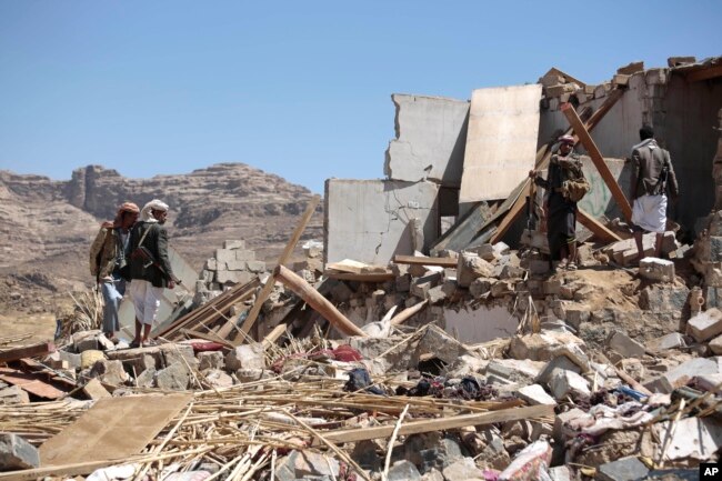 FILE - People inspect the rubble of a house destroyed by a Saudi-led airstrike in the outskirts of Sana'a, Yemen, Feb. 16, 2017.