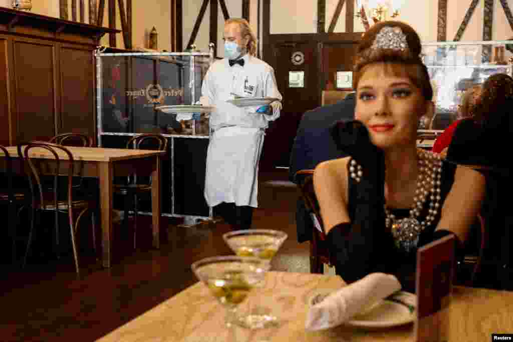 Madame Tussauds&#39;s wax figure of Audrey Hepburn sits at an empty table to comply with COVID-19 social distancing requirements in a dining room at Peter Luger Steak House in Brooklyn, New York February 26, 2021.