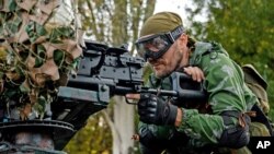 A Pro-Russian rebel prepares his weapon for the the assault on the positions of the Ukrainian army at the Donetsk airport, eastern Ukraine, Aug. 31, 2014. 