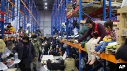 Migrants settle in a logistics center at the checkpoint "Kuznitsa" at the Belarus-Poland border near Grodno, Belarus, on Nov. 19, 2021.