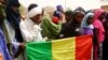 People seeking refuge from Tuareg separatist rebel group MNLA display a Malian flag in a military camp in the northern town of Kidal, July 17, 2013. 