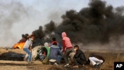 Palestinian protesters take cover during clashes with Israeli troops along Gaza's border with Israel, east of Khan Younis, Gaza Strip, April 5, 2018. A new round of protests along the border is expected Friday.