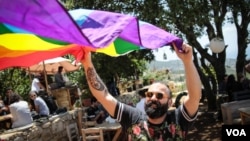 A man unfurls the rainbow flag at a small event held by Beirut Pride, May 21, 2017. (J. Owens/VOA)