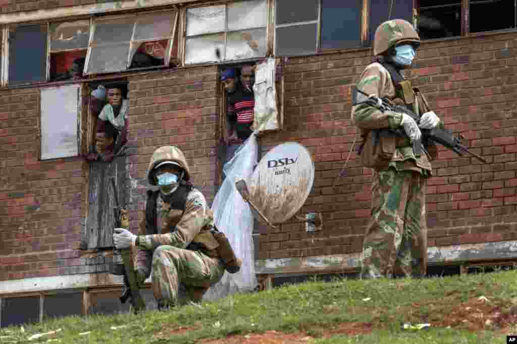South African National Defense Forces patrol the Men&#39;s Hostel in the densely populated Alexandra township east of Johannesburg, March 28, 2020, enforcing a strict lockdown in an effort to control the spread of the coronavirus.