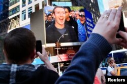 FILE - Facebook Inc. CEO Mark Zuckerberg is seen on a screen televised in New York from the company's headquarters in Menlo Park, California.