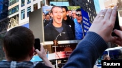 FILE - Facebook Inc. CEO Mark Zuckerberg is seen on a screen televised in New York from the company's headquarters in Menlo Park, California.