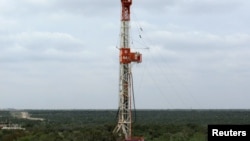 FILE - A rig drills a horizontal well in a search for oil and natural gas in the Wolfcamp shale located in the Permian Basin in West Texas, U.S.