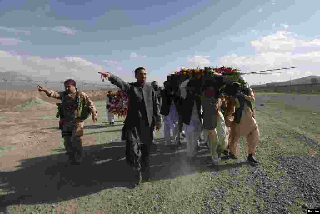 Afghans carry the coffin of Arsala Jamal, governor of Logar province, who was killed in an attack on a mosque, during a burial ceremony in Kabul.