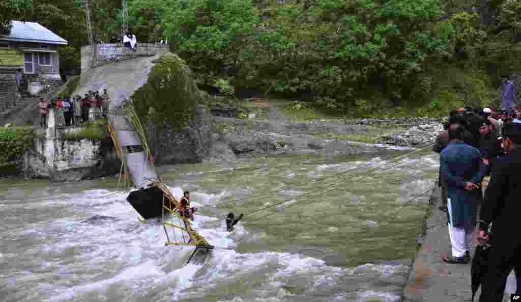 Pakistani rescue workers search for bodies at the site of bridge collapse in Kundal Shahi, some 75 kilometers (47 miles) north of Muzaffarabad, the capital of Pakistani-controlled Kashmir.