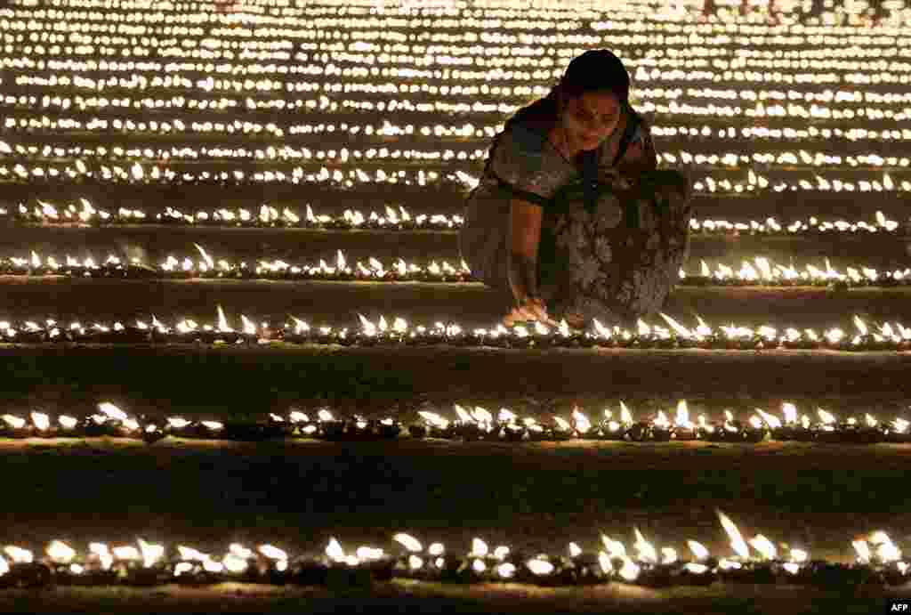 A Hindu devotee lights oil lamps as part of "Laksha Deepotsava" (celebration of a hundred thousand lights), during the Makara Sanranti Festival in Bangalore. Makar Sankranti is a festival celebrated in almost all parts of India, Nepal and Bangladesh in many cultural forms.
