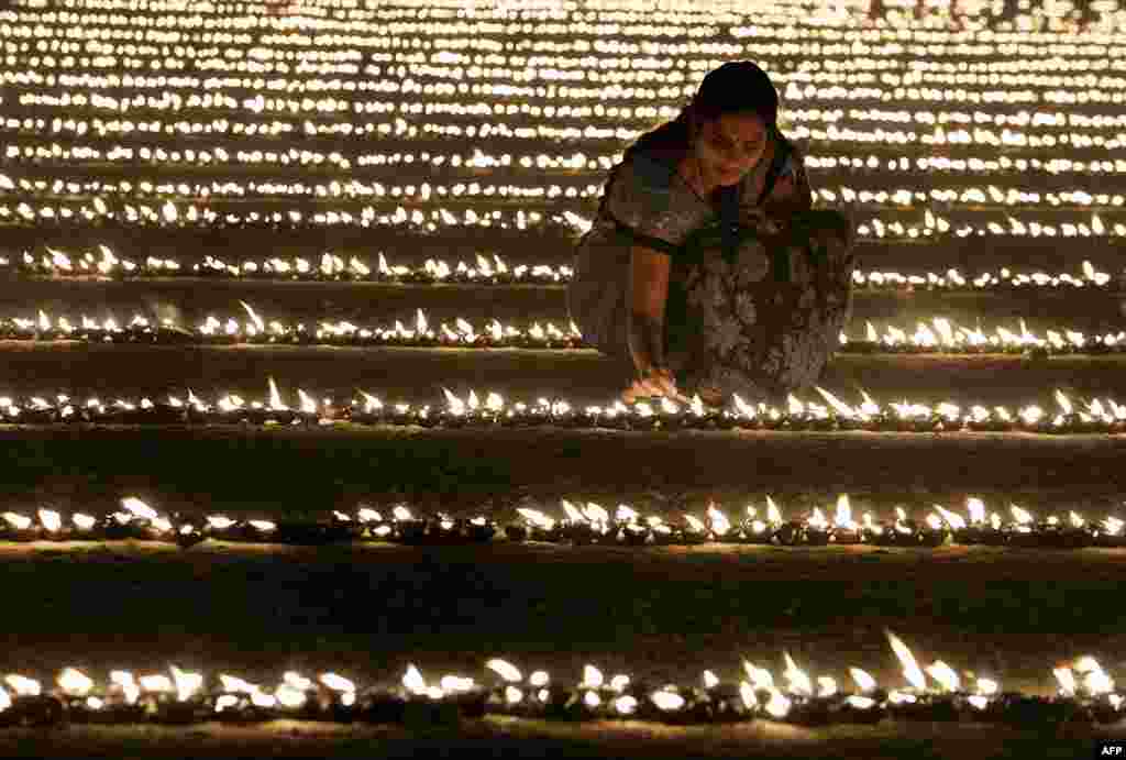 A Hindu devotee lights oil lamps as part of &quot;Laksha Deepotsava&quot; (celebration of a hundred thousand lights), during the Makara Sanranti Festival in Bangalore. Makar Sankranti is a festival celebrated in almost all parts of India, Nepal and Bangladesh in many cultural forms.