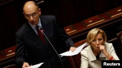 Newly appointed Italian Prime Minister Enrico Letta (L) speaks next to Foreign Minister Emma Bonino at the Lower House of the parliament in Rome, April 29, 2013. 