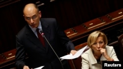 Newly appointed Italian Prime Minister Enrico Letta (L) speaks next to Foreign Minister Emma Bonino at the Lower House of the parliament in Rome, April 29, 2013.