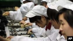 Công nhân làm việc trong dây chuyền sản xuất trong một xí nghiệp Foxconn ở Thâm Quyến