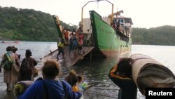 Para penduduk membawa harta-benda milik mereka menaiki kapal di Pelabuhan Lolowai dalam proses evakuasi akibat letusan gunung Manaro Voui yang melontarkan asap dan debu vulkanis di Pulau Ambae, sebelah utara Vanuatu, di Pasifik Selatan, 1 Oktober 2017.