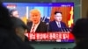 FILE - People watch a television news screen showing pictures of U.S. President Donald Trump and North Korean leader Kim Jong Un at a railway station in Seoul, Nov. 29, 2017.