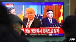 Moun kap gade nouvèl sou televizyon ki montre foto Prezidan Donald Trump ak lidè Kore di Nö a, Kim Jong Un. (Foto: 29 novanm 2017).