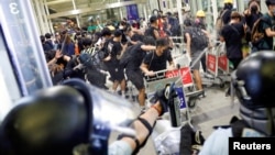 2019年8月13日，香港國際機場防暴警察使用胡椒噴霧驅散反引渡法案抗議者。