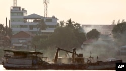 In this 2010 photo, a private boat dredges sand in the Mekong river near Phnom Penh, Cambodia.