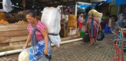Perempuan kuli panggul mendapat upah dengan membawa puluhan kilogram barang milik pembeli atau pedagang di Pasar Legi Solo Jawa Tengah, Kamis, 7 Maret 2018. Mereka perempuan perkasa yang jadi "tulang punggung" keluarga. (Foto: Yudha Satriawan/VOA)