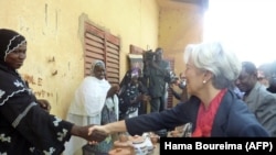 Tổng giám đốc Quỹ Tiền tệ Quốc tế IMF Christine Lagarde bắt tay với một người làm đồ gốm tại làng Boubon, Niger (ảnh chụp ngày 21/12/2011)