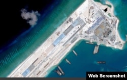 Satellite image of what is claimed to be an under-construction airstrip at Fiery Cross Reef in the Spratly islands in the disputed South China Sea. Web Screemshot theguardian.com