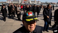 A delegate to the Chinese People's Political Consultative Conference wears a cap with the words "Chinese navy guardian of the Spratly Islands" as he arrives at Beijing's Great Hall of the People for a plenary session, March 9, 2015. 