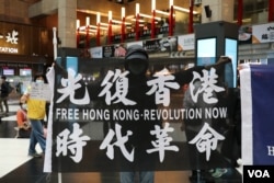 资料照：在台北车站参与支持香港行动的民众高举“光复香港时代革命”旗帜。 （2020年5月23日）