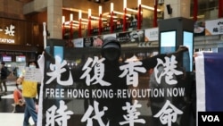 在台北車站參與支持香港行動的民眾高舉“光復香港時代革命”旗幟。（2020年5月23日）