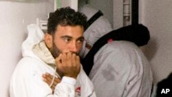 Le navigateur tunisien Mohammed Ali Malek, et l'un des survivants du bateau qui s'est renversé au large de la Libye, en attendant d’être débarqués du navire de la Garde côtière italienne Bruno Gregoretti, au port de Catane, en Italie, le 20 avril 2015. (AP Photo/Alessandra Tarantino, File)