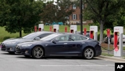 Telsa cars recharge at a Tesla station at a shopping center in Charlotte, N.C., June 24, 2017. Buyers of Tesla’s luxury models have access to a company-funded Supercharger network. 