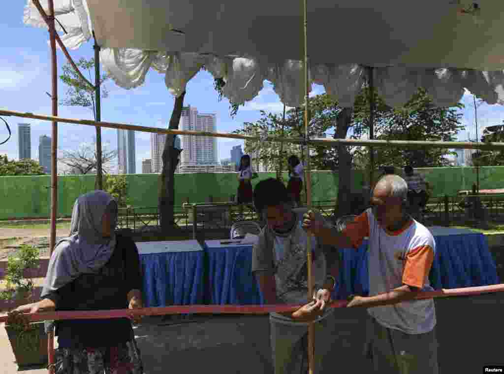 Volunteers make preparations at a polling station for the upcoming parliamentary election in Jakarta, April 8, 2014. 
