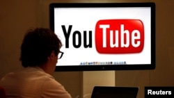 Un hombre trabaja frente una pantalla con el logo de YouTube. [Foto de archivo]