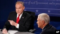 Senatè Tim Kaine (kravat wouj) tap reponn yon kesyon pandan Gouvènè Pence tap koute.