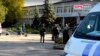 Para petugas kepolisian dan penyidik berdiri di dekat sekolah kejuruan di Kerch, Krimea, 17 Oktober 2018.