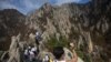 FILE – A North Korean man records video while climbing his country’s Mount Kumgang in 2012. Some South Korean firms hope to resume a project involving tours to that area. 