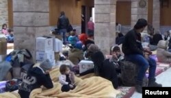 A still image taken from a video, said to be shot Jan. 4, 2017, shows civilians, who were evacuated from Wadi Barada, sitting inside a shelter in the Damascus suburb of Rawda, Syria.